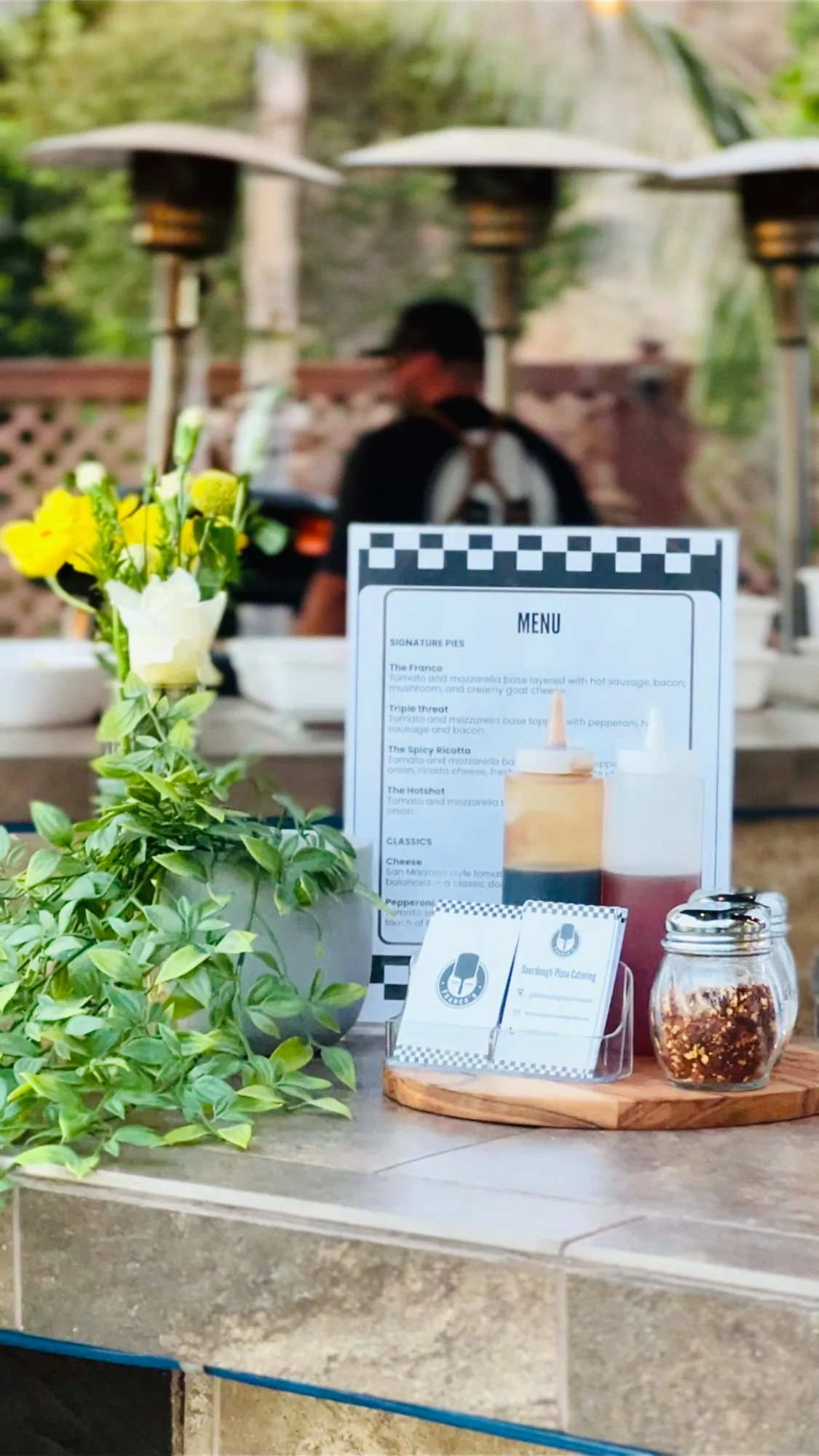The Franco's table set up with flowers and a printed menu board.